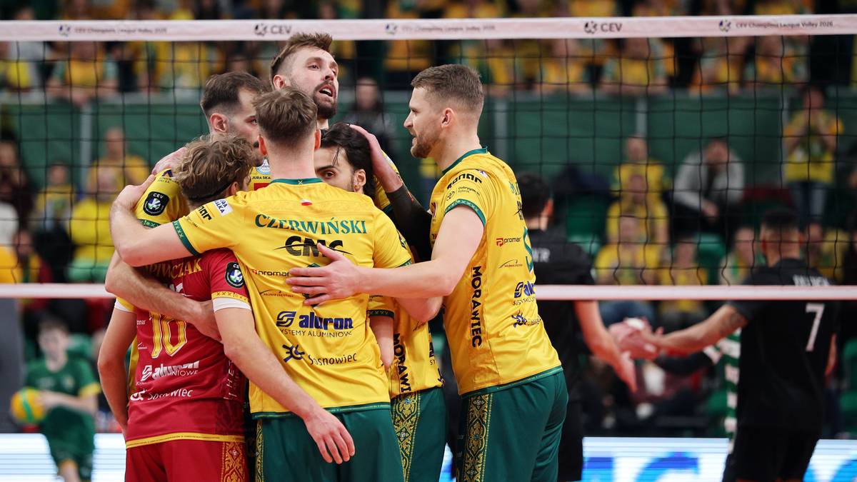 Siatkarze Aluron CMC Warta Zawiercie świętują zwycięstwo, przytulając się na boisku.