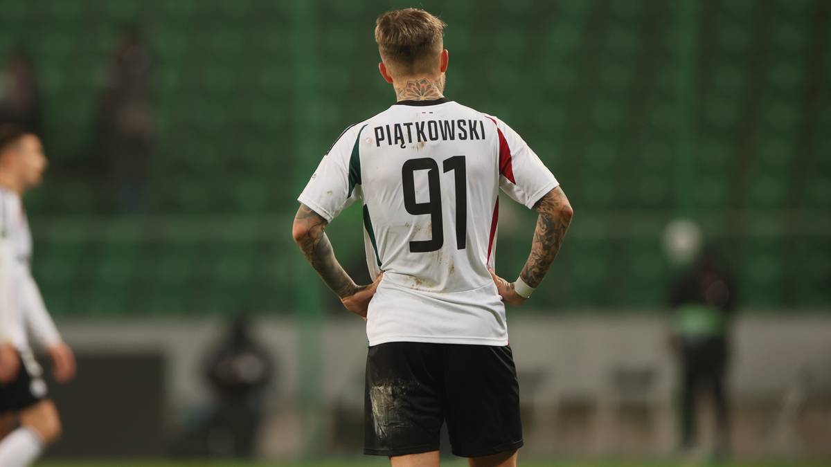 Piłkarz z numerem 91 na plecach na tle stadionu.