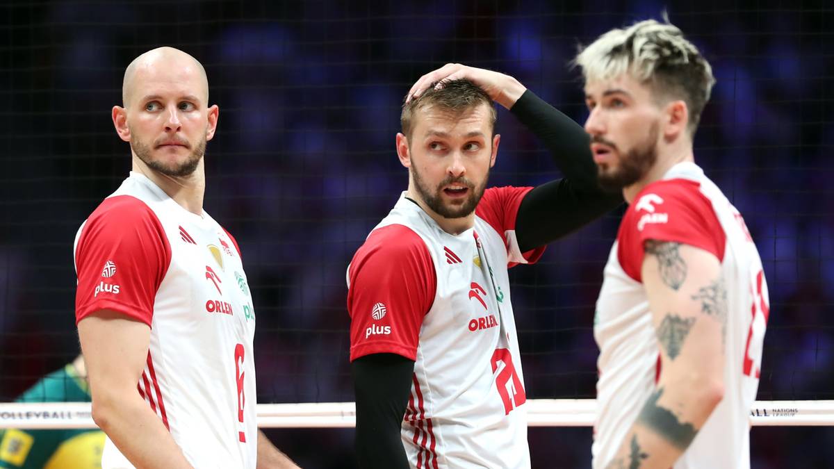 Trzech siatkarzy w biało-czerwonych strojach reprezentacji Polski, dwóch spogląda w stronę obiektywu, jeden poprawia włosy.