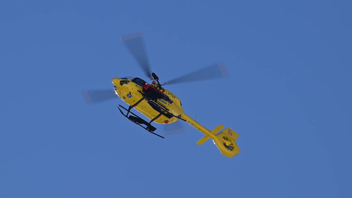 Ż&oacute;łty helikopter ratunkowy w locie na tle błękitnego nieba.