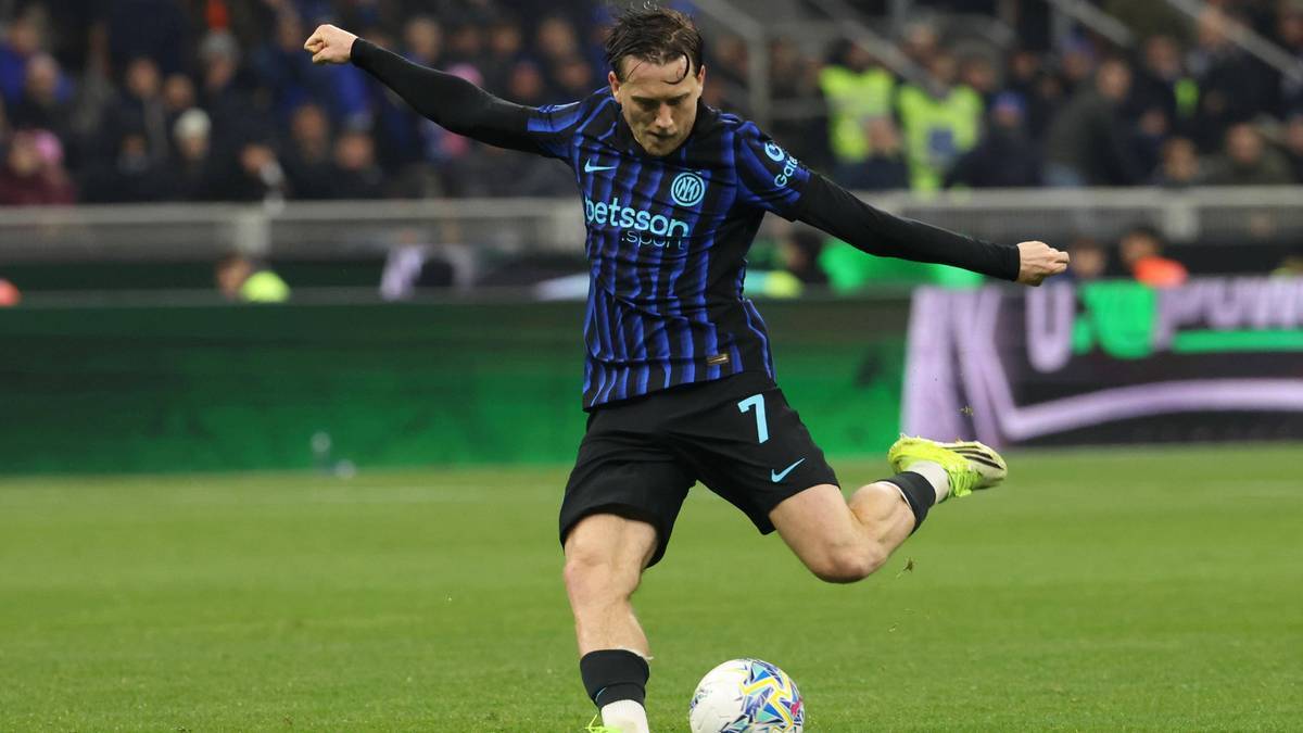 Piłkarz w niebiesko-czarnej koszulce z numerem 7 na plecach oddaje strzał na bramkę.