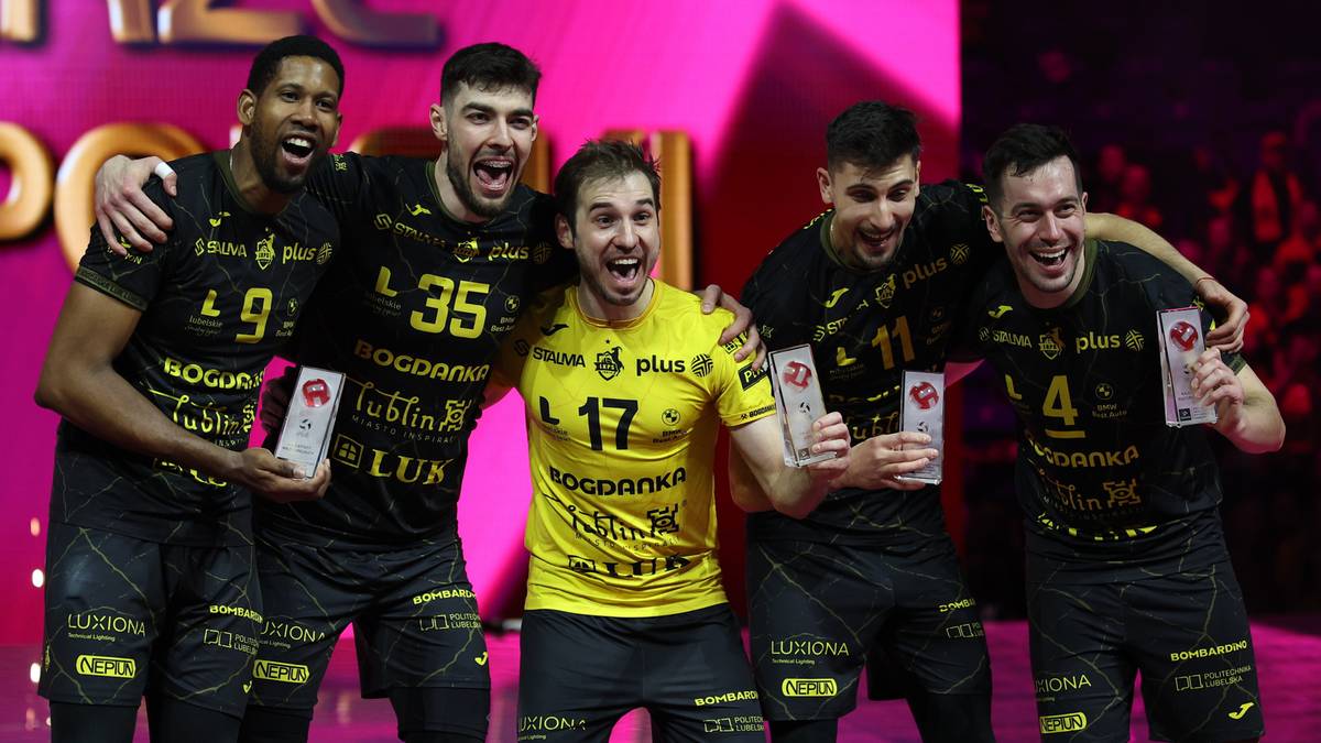 Sześciu siatkarzy w czarnych strojach pozuje do zdjęcia, trzymając w dłoniach statuetki i dyplomy.