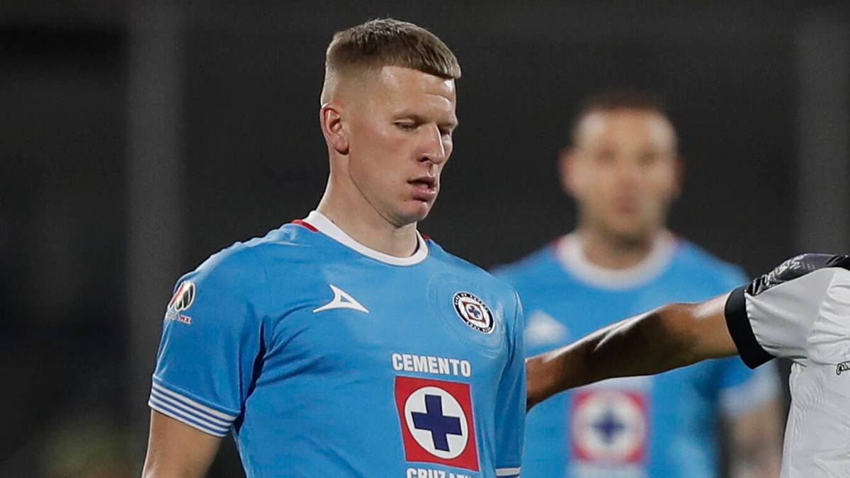 Piłkarz w niebieskiej koszulce patrzy w dół ze zmęczoną miną.