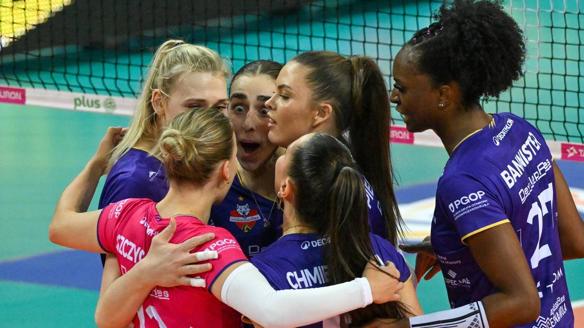 Grupa siatkarek w strojach sportowych obejmuje się, celebrując punkt lub zwycięstwo.