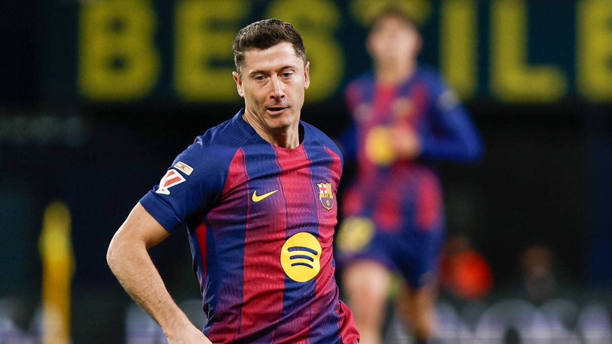 Dwóch piłkarzy na boisku podczas meczu, jeden w żółtym stroju, drugi w stroju FC Barcelony.