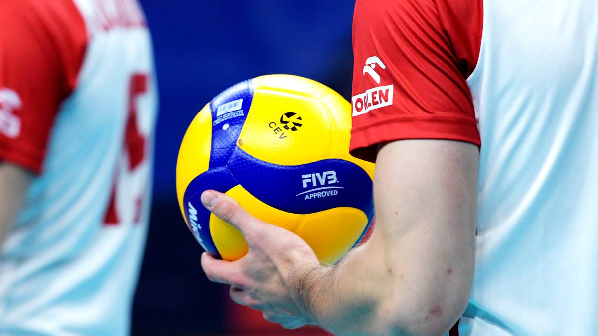 Siatkarz trzymający piłkę do siatkówki.
