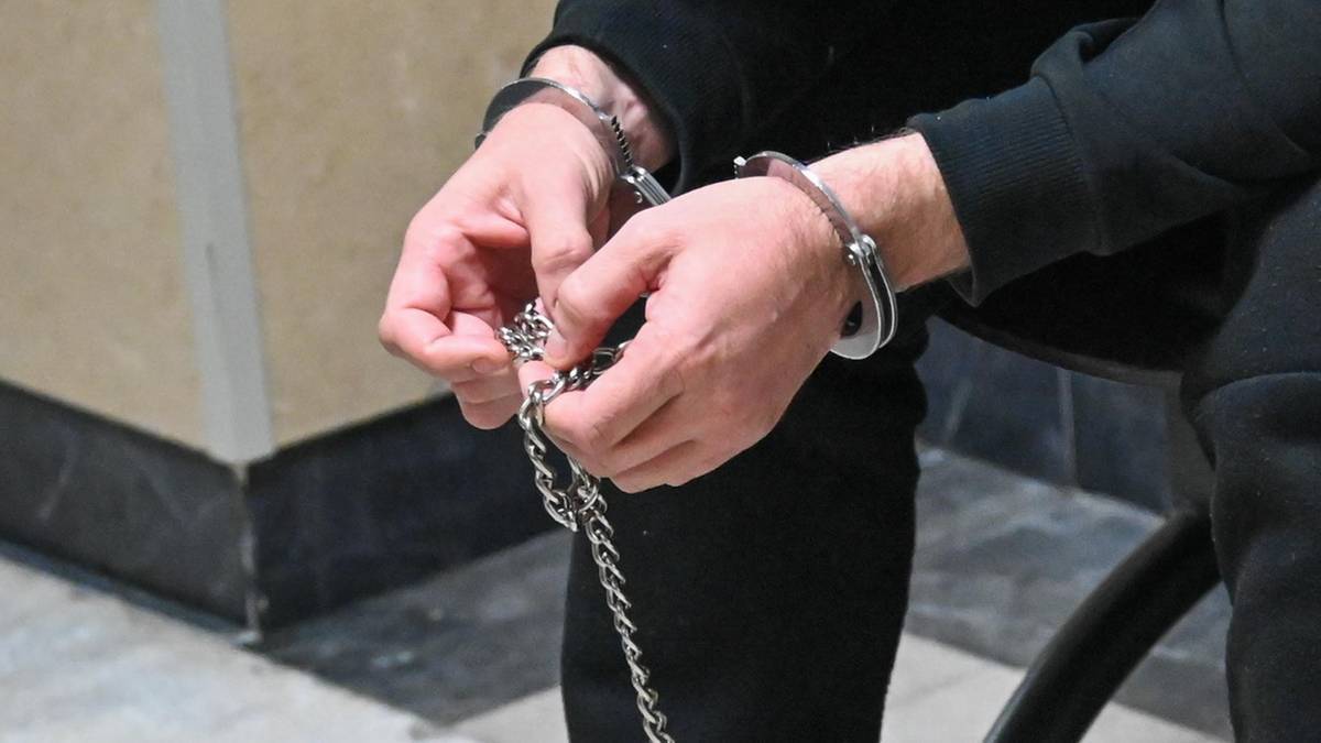 Dłonie zapięte w kajdanki.