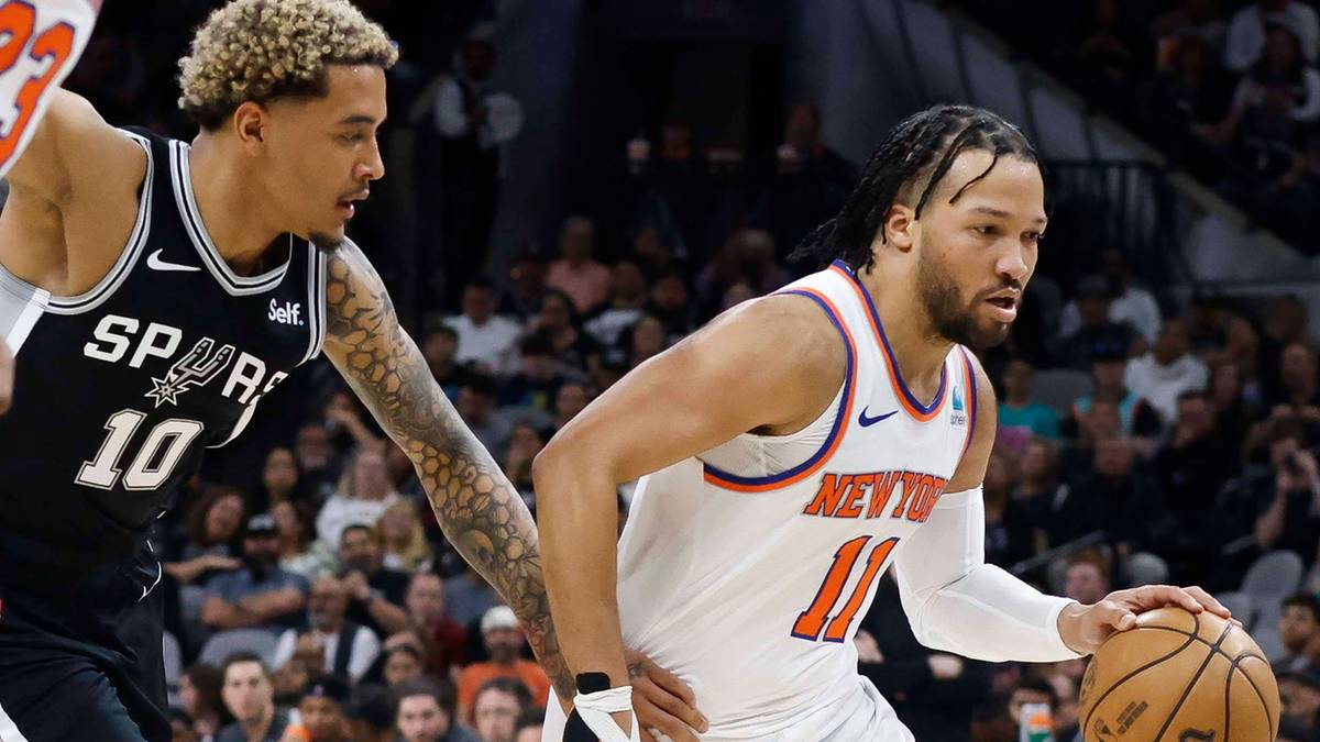 Dw&oacute;ch koszykarzy w akcji podczas meczu NBA. Jeden w stroju San Antonio Spurs z numerem 10, drugi w stroju New York Knicks z numerem 11.