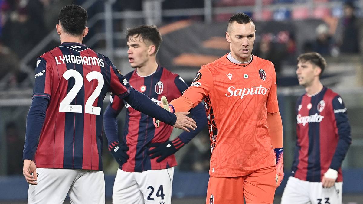 Piłkarze w strojach piłkarskich na boisku.