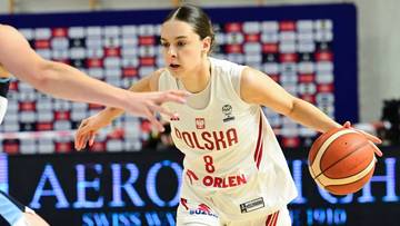 Koszykarka w białej koszulce z numerem 8 pr&oacute;buje odebrać piłkę przeciwniczce podczas meczu.