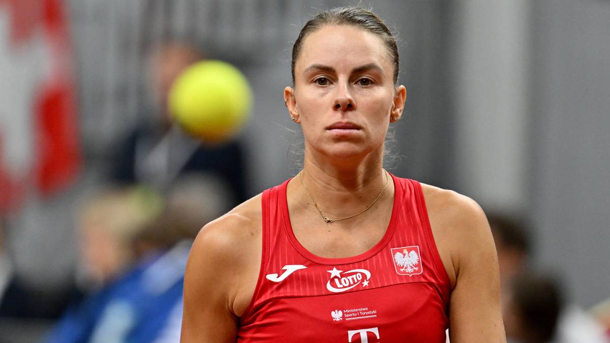 Magda Linette, polska tenisistka, w czerwonym stroju sportowym, podczas meczu, zdeterminowana.