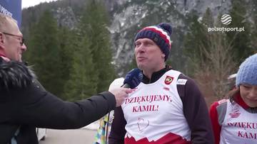 Rafał Chmiel w zimowej czapce i kamizelce z napisem "Dziękujemy, Kamil!" udziela wywiadu na tle g&oacute;rskiego krajobrazu.