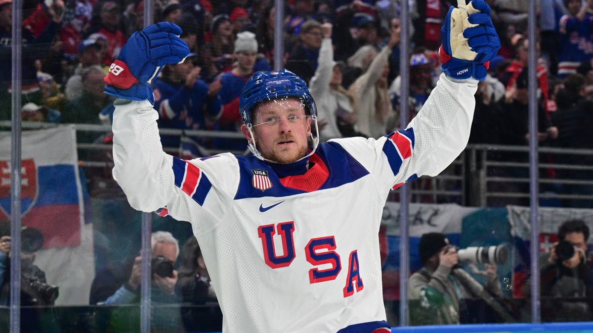 Hokeista reprezentacji USA w białej koszulce z napisem USA, świętujący zwycięstwo.