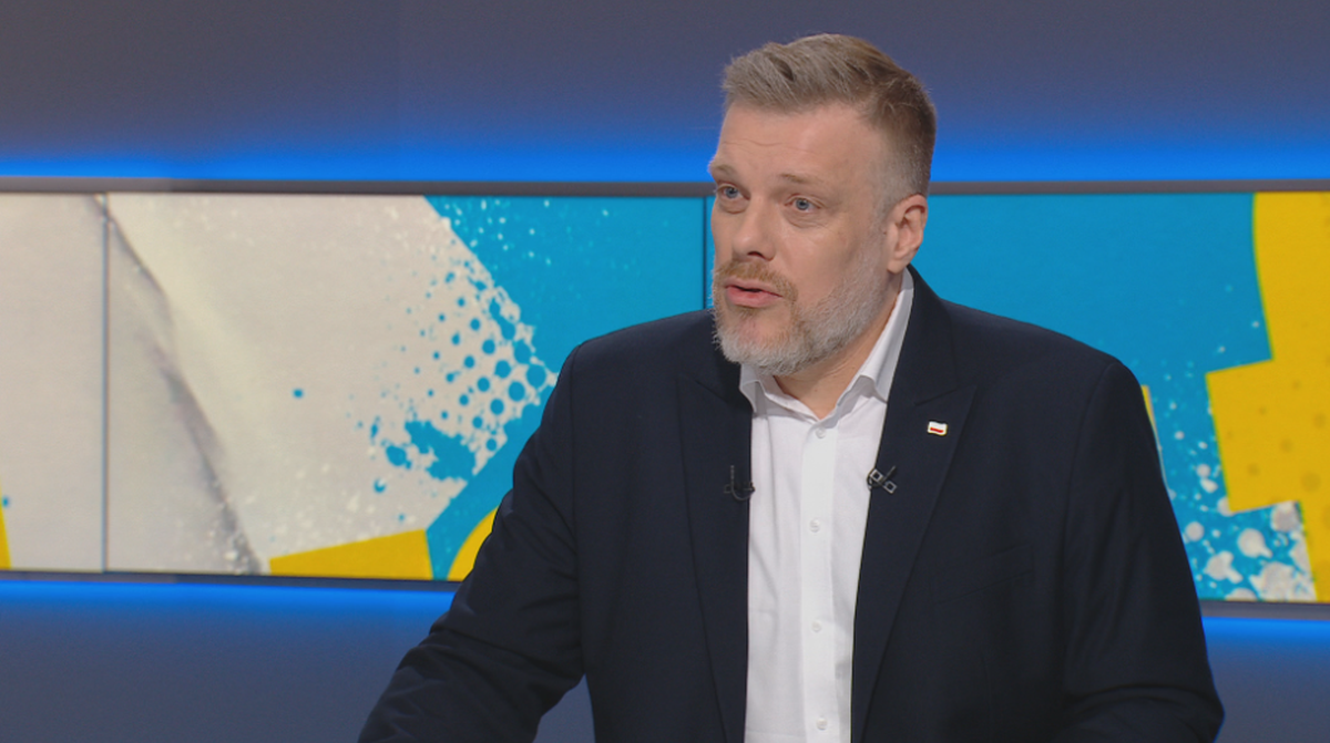 Adrian Zandberg w studiu telewizyjnym podczas wywiadu.