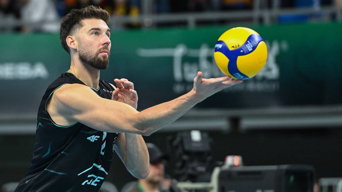 Siatkarz Bartosz Bednorz w akcji, trzymający piłkę do siatk&oacute;wki na otwartej dłoni.