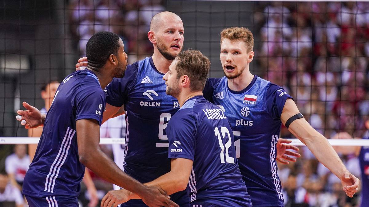 Czterech polskich siatkarzy w granatowych strojach reprezentacji Polski stoi blisko siebie podczas meczu.