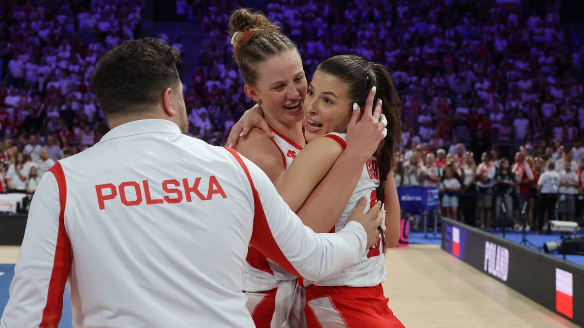 Trzy osoby świętujące zwycięstwo na boisku do koszyk&oacute;wki, dwie kobiety przytulają się, a trzecia osoba z napisem POLSKA na bluzie obejmuje jedną z nich.