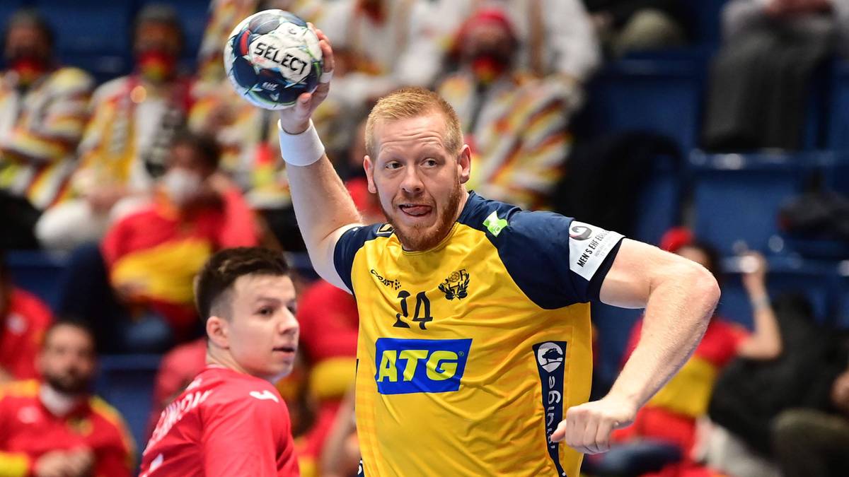 Piłkarz ręczny w ż&oacute;łtej koszulce z numerem 14 podrzuca piłkę do g&oacute;ry.