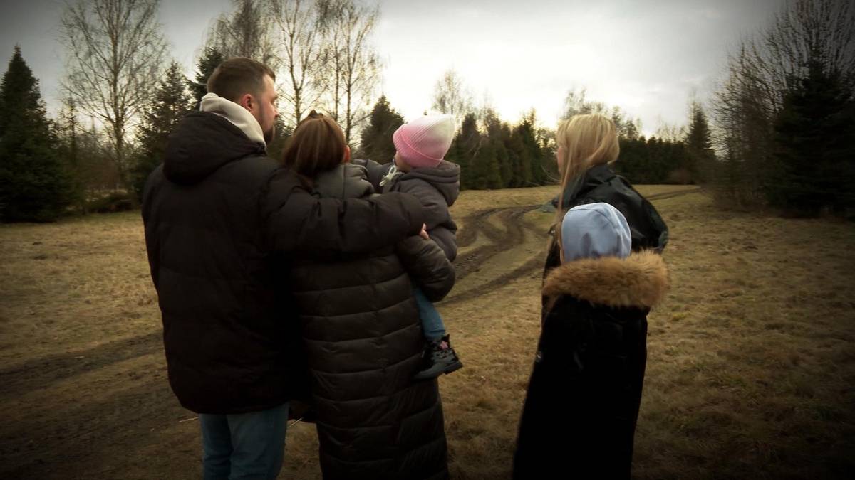 Rodzina stojąca na pustej działce budowlanej