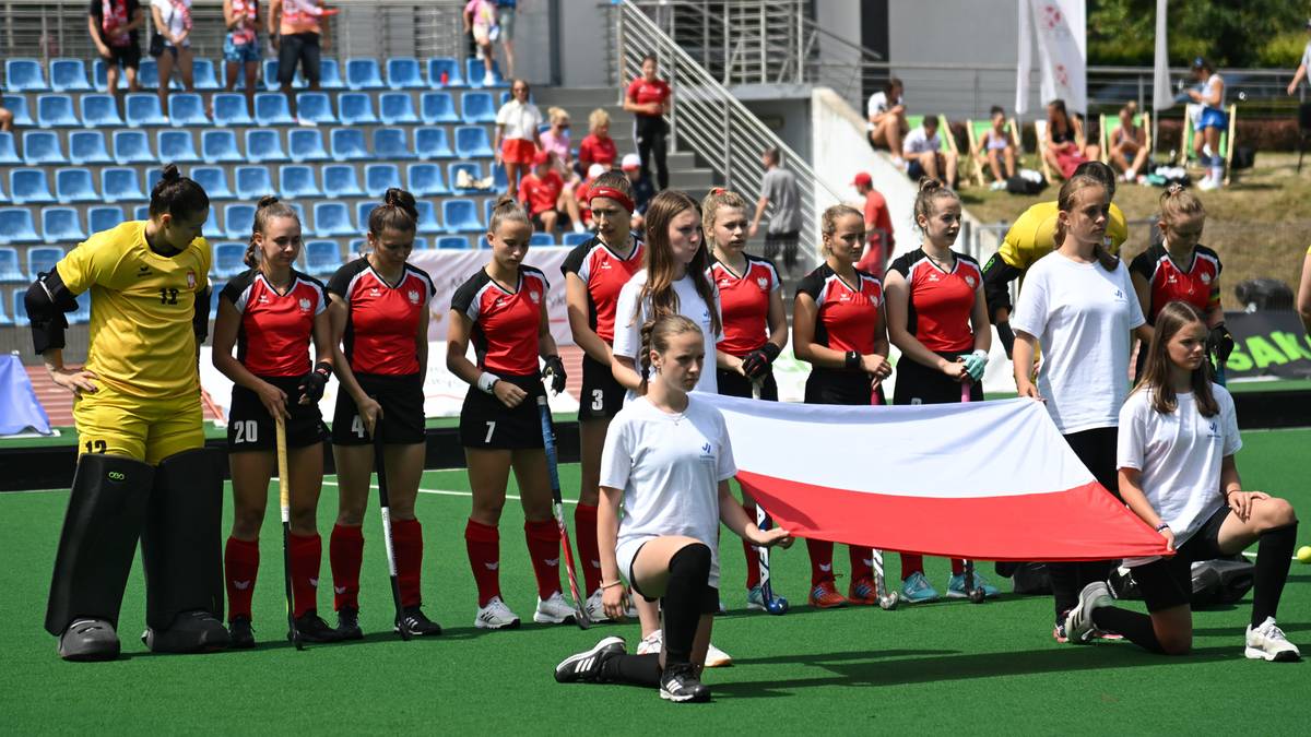 Drużyna hokeja na trawie Polski z flagą narodową po wygranej.