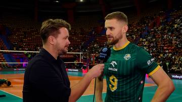 Siatkarz w zielonej koszulce z numerem 9 udziela wywiadu na tle stadionu.