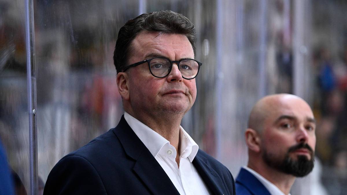 Portret trenera hokejowego w okularach na tle innych os&oacute;b.