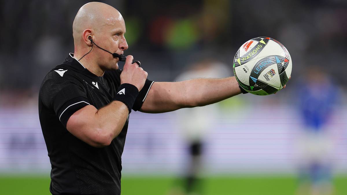 Sędzia piłkarski z gwizdkiem i piłką w ręce