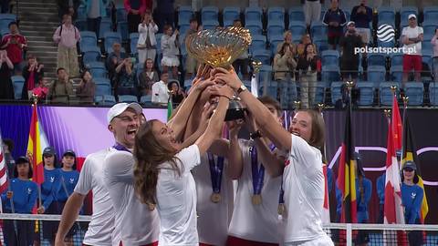 Grupa tenisist&oacute;w w białych strojach podnosi do g&oacute;ry puchar United Cup, ciesząc się ze zwycięstwa.