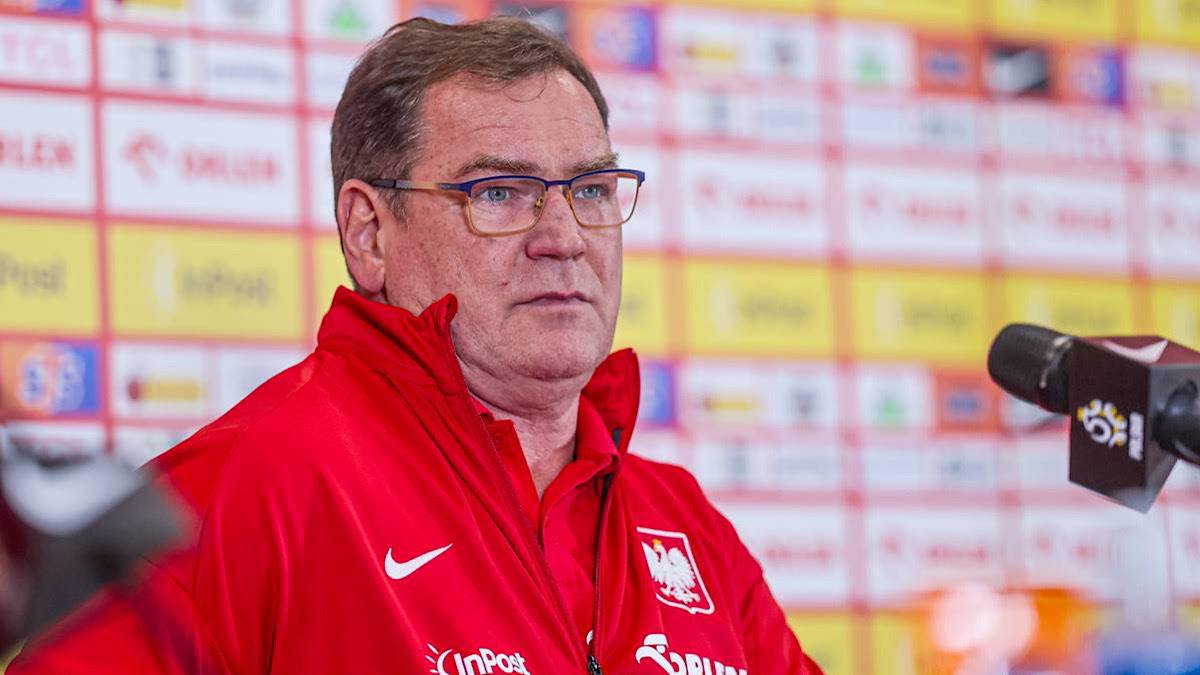 Jan Urban w czerwonej kurtce reprezentacji Polski przed mikrofonem