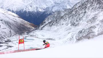 Narciarka zjeżdżająca po ośnieżonym stoku g&oacute;rskim.