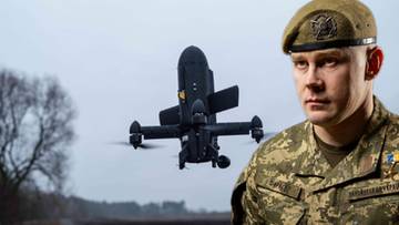 Czarny dron leci w powietrzu obok wojskowego w mundurze i beret w kolorze khaki.