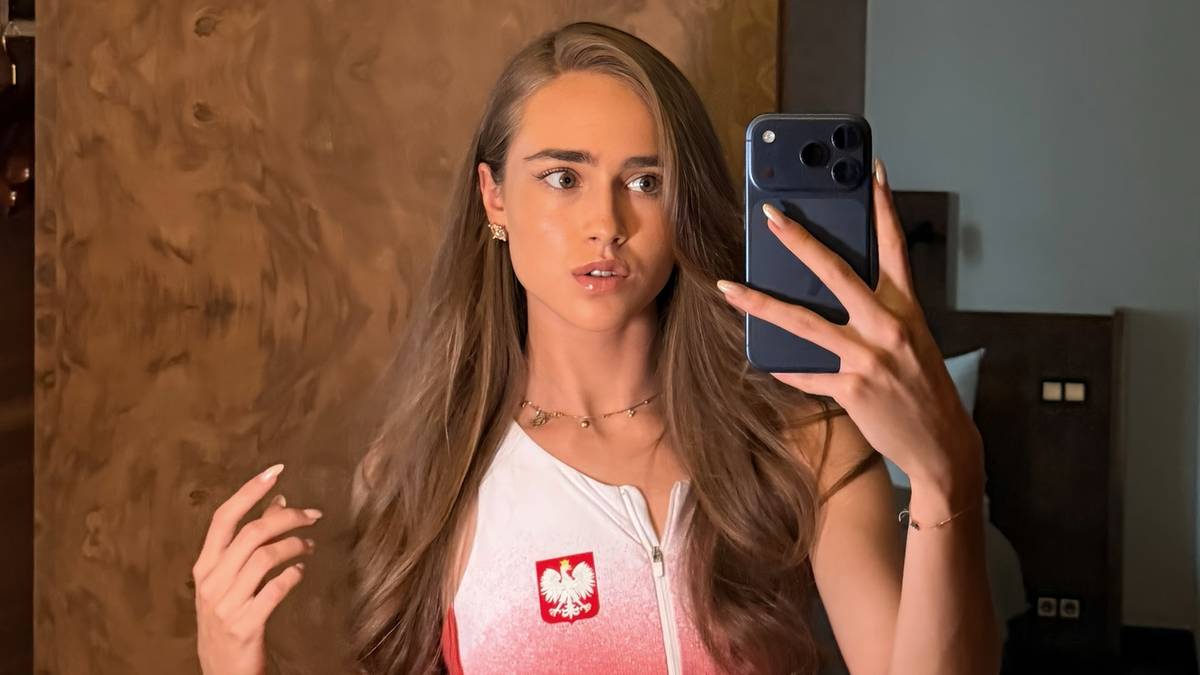 Kobieta w stroju sportowym z godłem Polski robi sobie zdjęcie telefonem kom&oacute;rkowym.