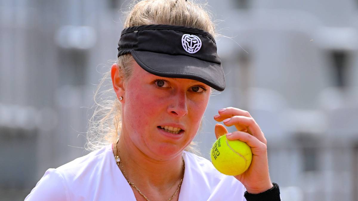 Portret tenisistki Magdaleny Fręch trzymającej piłkę tenisową w prawej dłoni.