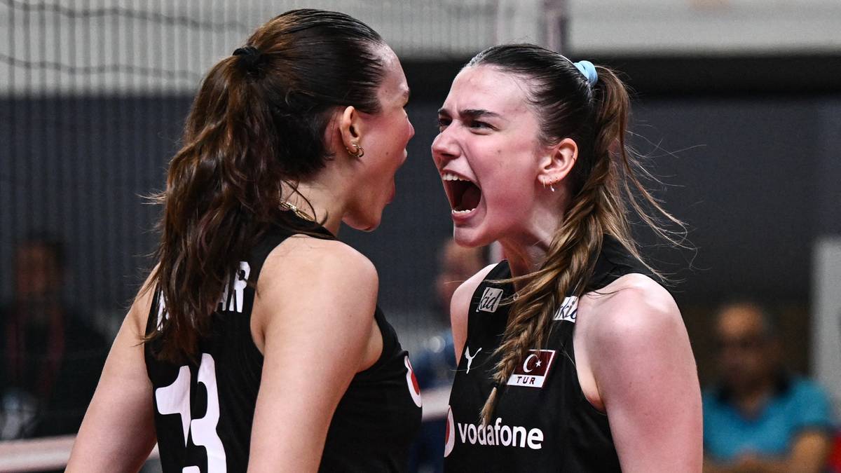 Dwie siatkarki w czarnych strojach sportowych krzyczą do siebie z bliskiej odległości, obie z otwartymi ustami i wyraźnymi emocjami na twarzach.