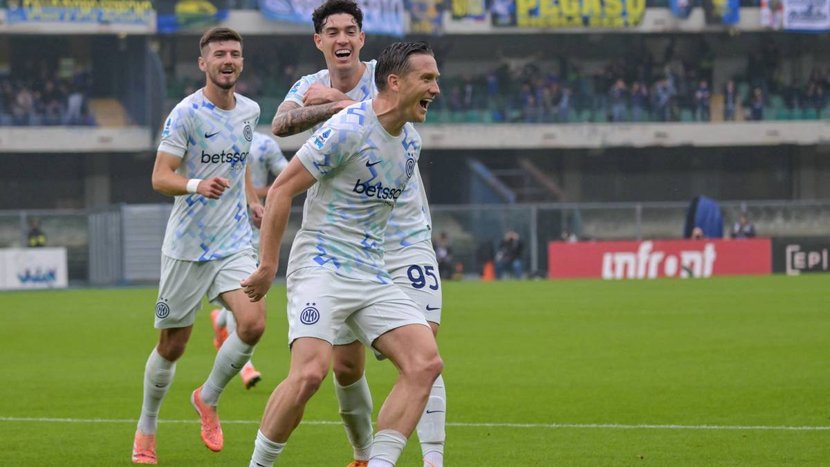 Piłkarz Piotr Zieliński w białej koszulce z numerem 95 świętuje zdobycie bramki, z kolegami z drużyny w tle.