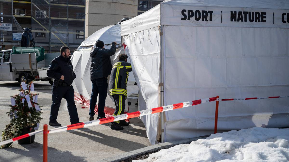 Osoby w strojach ochronnych wchodzą do białego namiotu pod namiotem z napisem "SPORT | NATURE | C"