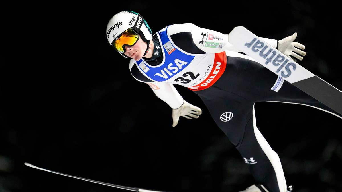 Skoczek narciarski w powietrzu podczas zawod&oacute;w.