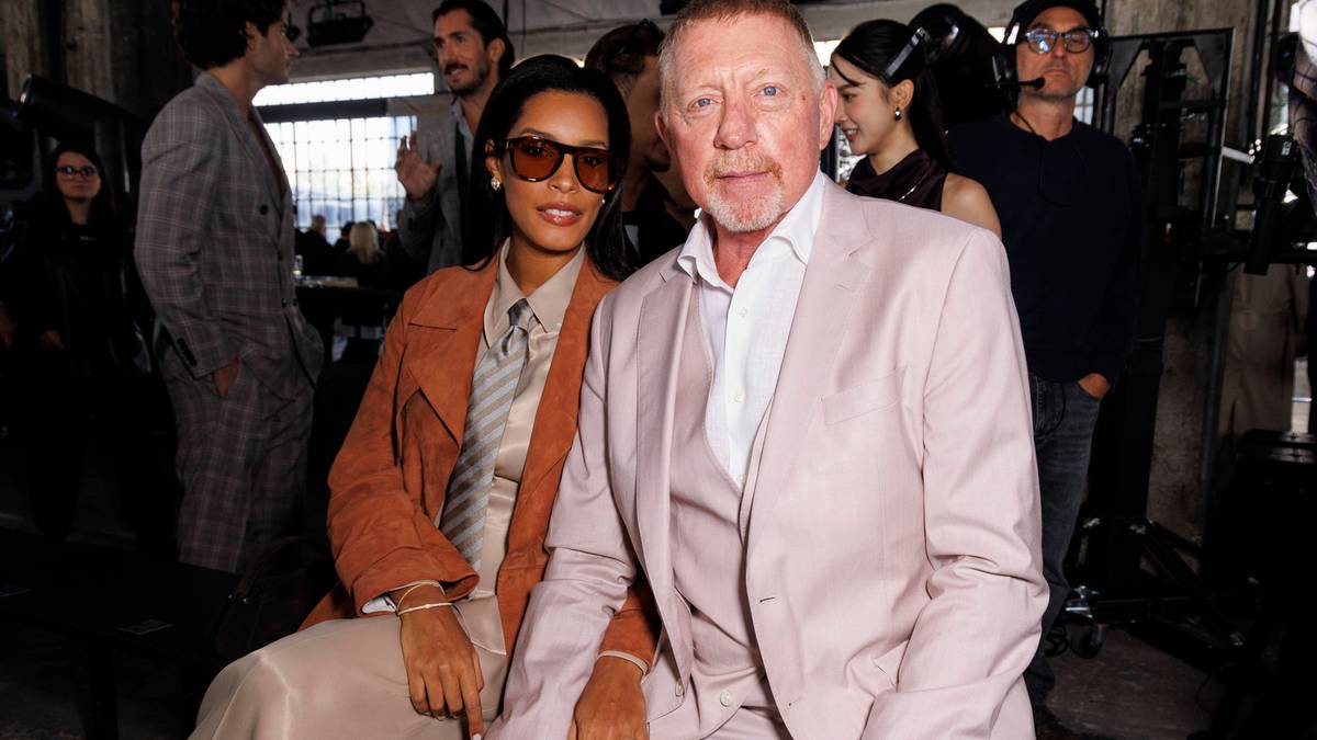 Boris Becker i jego partnerka siedzą razem, oboje ubrani elegancko.