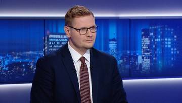 Mariusz Marszałkowski, ekspert ds. obronności, siedzi w studiu telewizyjnym, ubrany w garnitur i krawat.