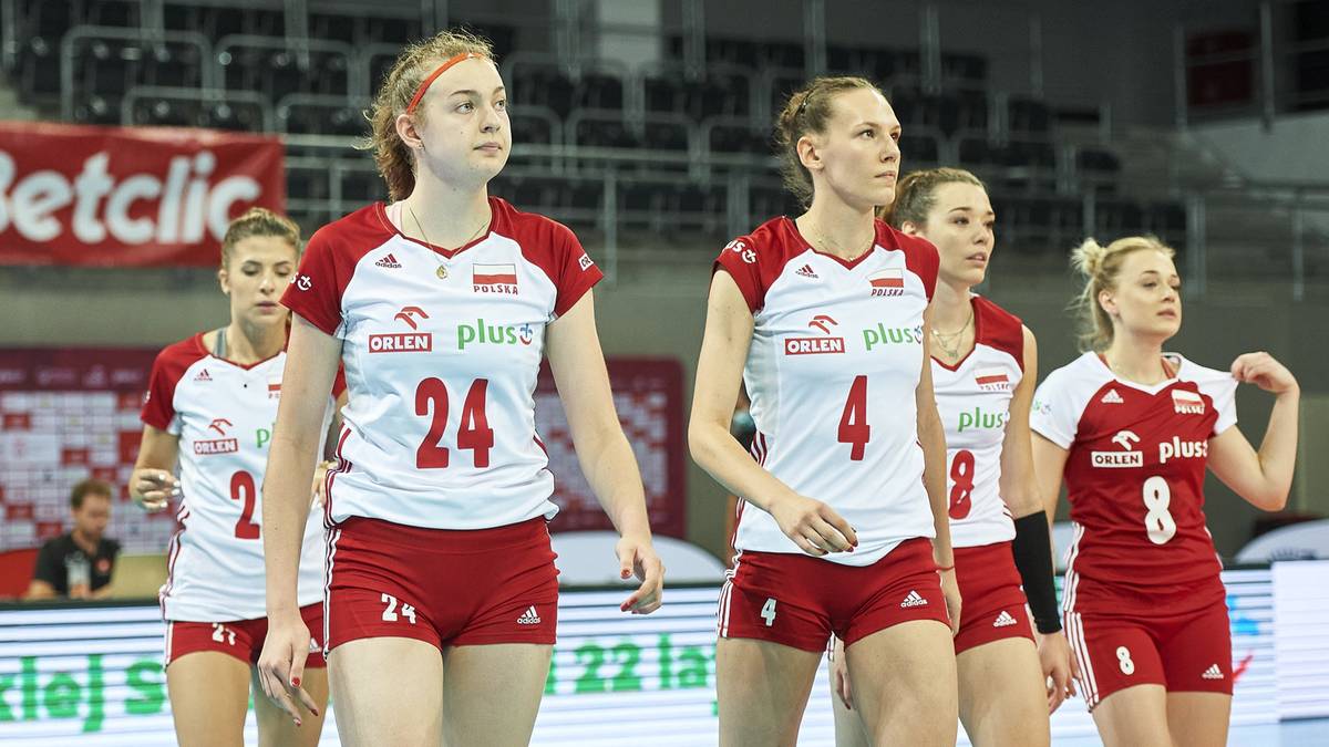 Siatkarki reprezentacji Polski w białych strojach z czerwonymi elementami, w tym numerami na koszulkach.
