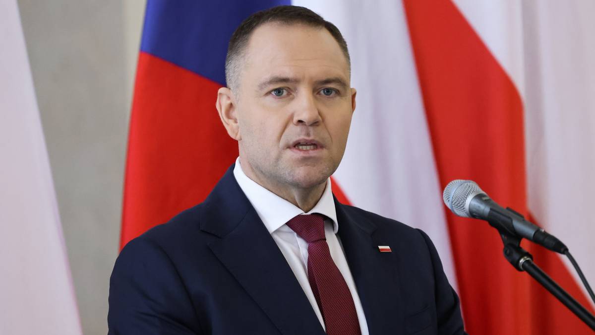 Prezydent Polski Andrzej Duda podczas konferencji prasowej przed polską i czeską flagą.