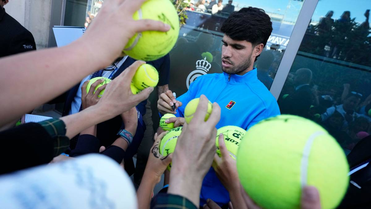 Carlos Alcaraz podaje piłki tenisowe fanom.