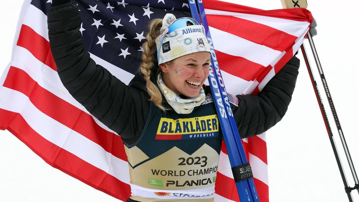 Uśmiechnięta biathlonistka z USA z flagą swojego kraju i nartami.