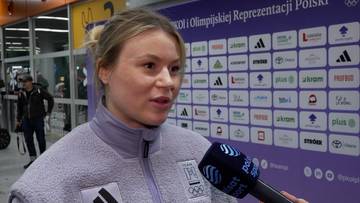 Natalia Maliszewska, polska panczenistka, udziela wywiadu przed ścianką z logotypami Polskiego Komitetu Olimpijskiego i reprezentacji Polski. Trzyma mikrofon Polsatu Sport.