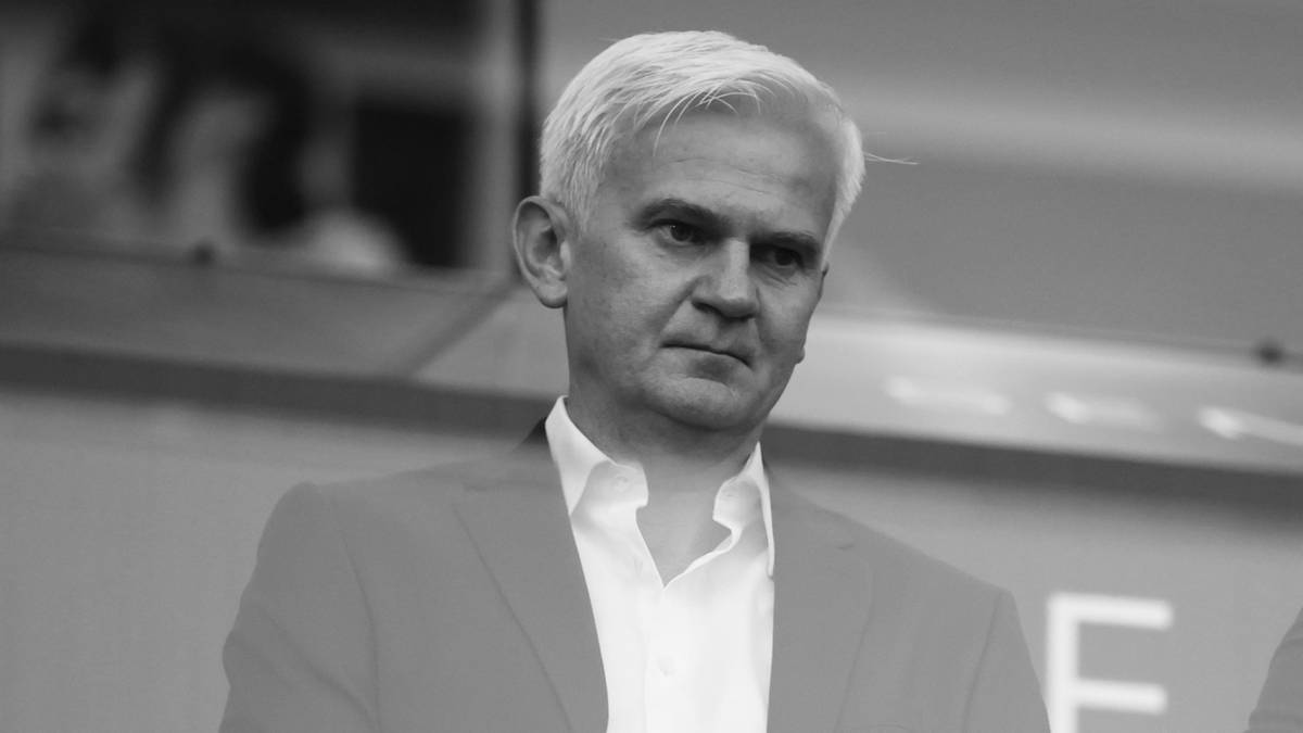 Dwóch mężczyzn w garniturach siedzących obok siebie, patrzących w tym samym kierunku.