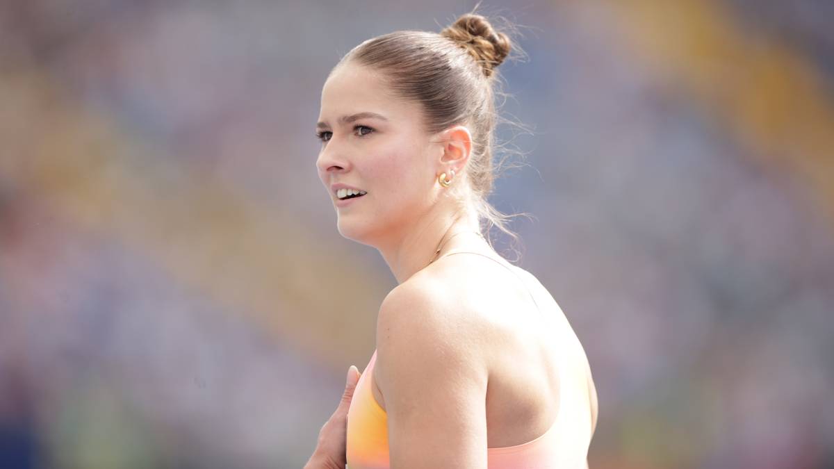 Portret kobiety lekkoatletki podczas zawod&oacute;w sportowych, z włosami spiętymi w kok i widocznym skupieniem na twarzy.