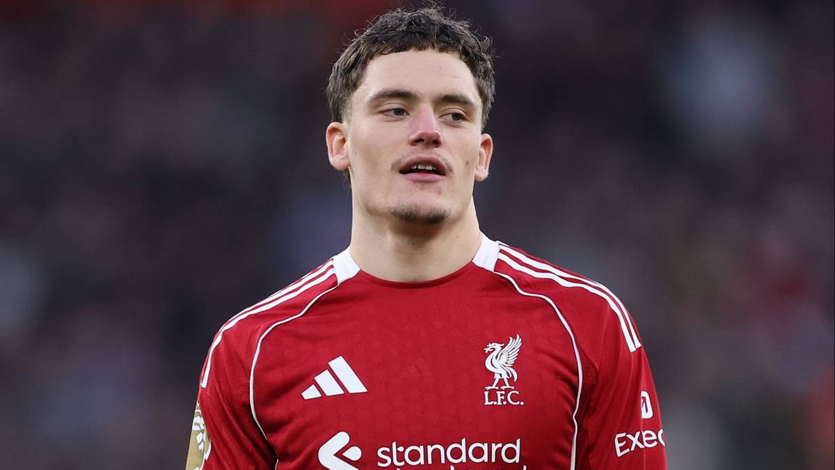 Piłkarz w czerwonej koszulce Liverpoolu z numerem 7 na spodenkach.