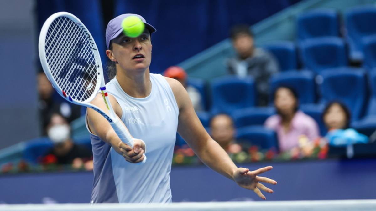 Tenisistka Iga Świątek podczas meczu, odbija piłkę rakietą.