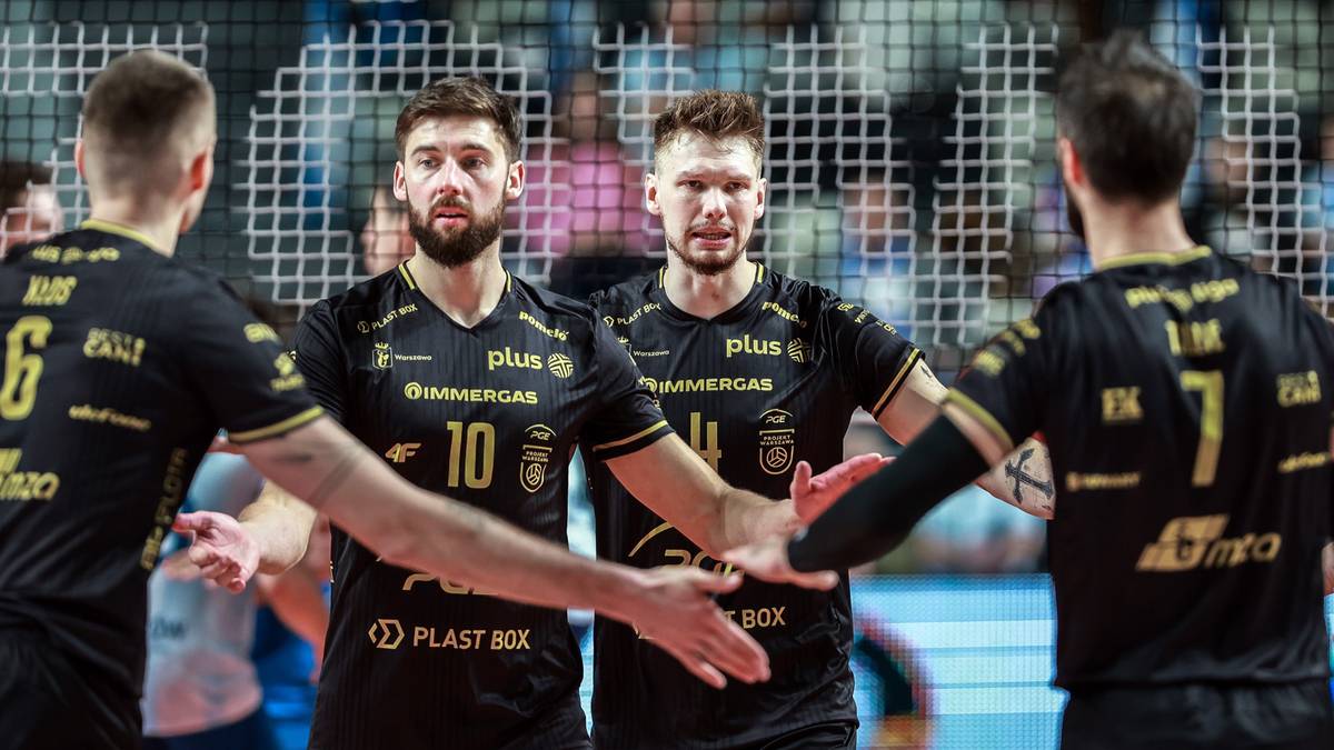 Siatkarze w czarnych koszulkach z żółtymi akcentami gratulują sobie nawzajem po meczu.