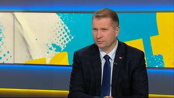 Przemysław Czarnek w garniturze i krawacie w studio telewizyjnym.
